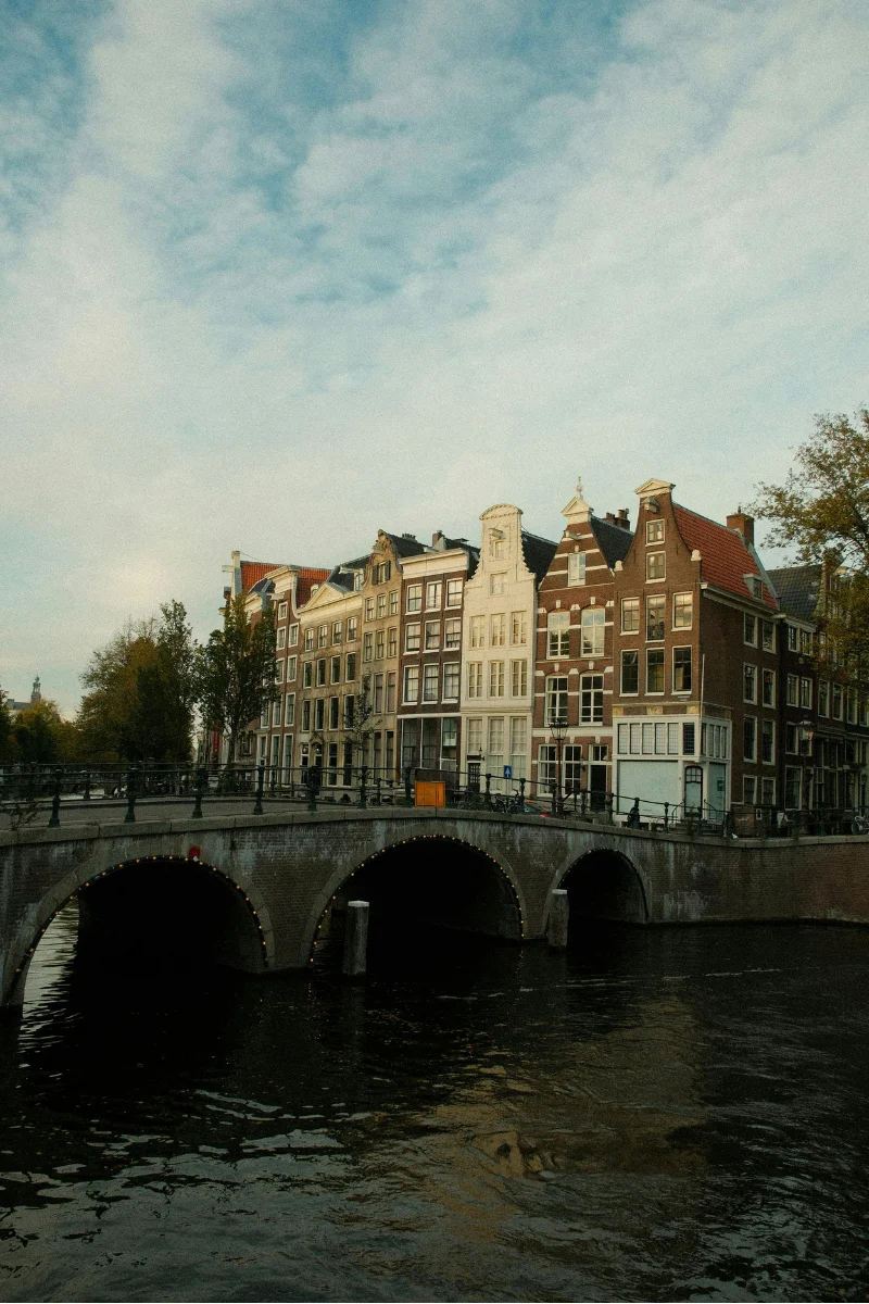 Hidden Amsterdam spots - golden hour sunset over quiet canal with reflections of historic buildings
